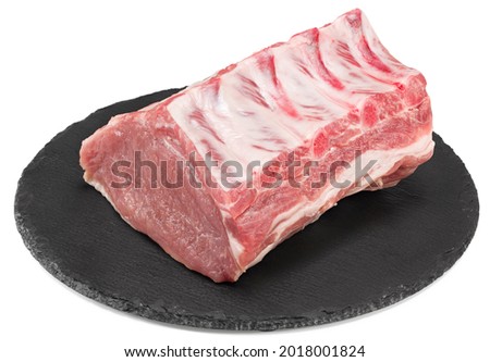 raw pork meat on black round stone plate isolated on white background. Clipping path and full depth of field