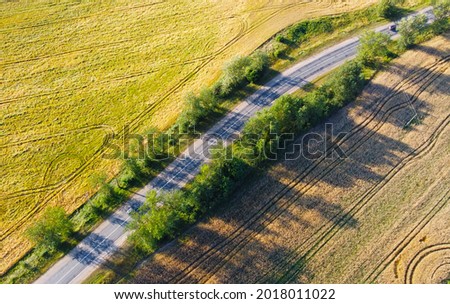 Aerial beautiful view of the summer landscape with a road near fields and meadows. Similar Tuscany countryside Italy