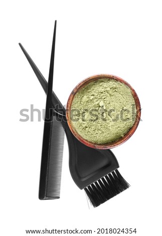 Bowl with henna, brush and hair comb on white background