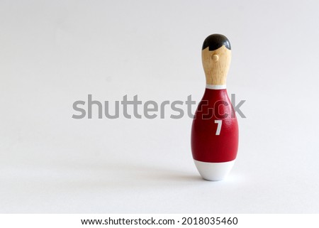 wooden puppet in the shape of a bowling pin with a number seven shirt