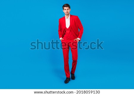 Full length photo of young handsome business man serious confident hands in pocket wear suit isolated over blue color background Royalty-Free Stock Photo #2018059130