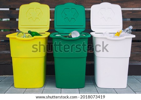 Three full dustbins for sorting trash on the backyard
