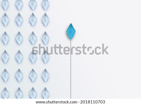 Group of white paper ship in one direction and one blue paper ship pointing in different way on white background. Business for innovative solution concept, copy space