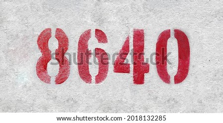 Red Number 8640 on the white wall. Spray paint. Number eight thousand six hundred forty.
