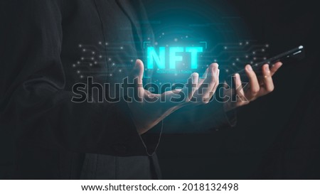 NFT non fungible tokens concept. Businessman with smartphone holding digital unique art NFT hologram on circuit board

binary background. Royalty-Free Stock Photo #2018132498