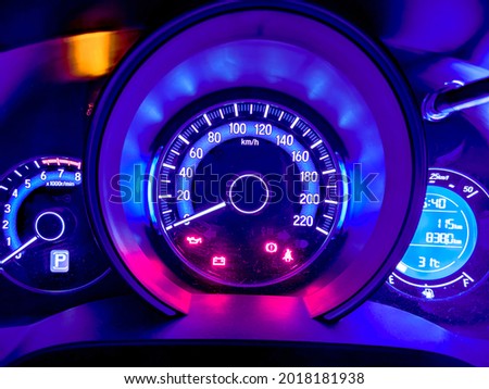 The vivid neon light in blue and magenta of car milage and speed panel during parking and many of safety icon and car status signal appearance.  Royalty-Free Stock Photo #2018181938