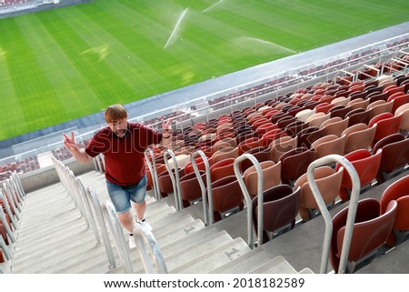 Portrait of man climbing stairs of football stadium Royalty-Free Stock Photo #2018182589