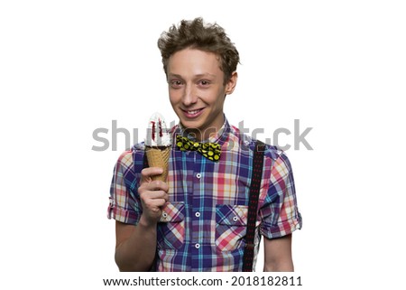 Smiling cheerful teenage boy with cone ice-cream.