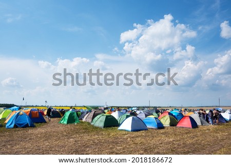 Tents on a music festival campsite. Blue sky with clouds on background Royalty-Free Stock Photo #2018186672