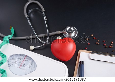 Weight loss scale with centimeter, stethoscope, Clipboard, pen. Diet concept. Healthy food background. different Nuts, sesame seeds. concept slimming diet.
