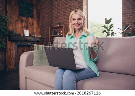 Portrait photo woman smiling using computer staying at home drinking tea spending free time