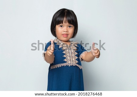 Asian little girl with ok sign gesture tumb up isolated on white background
