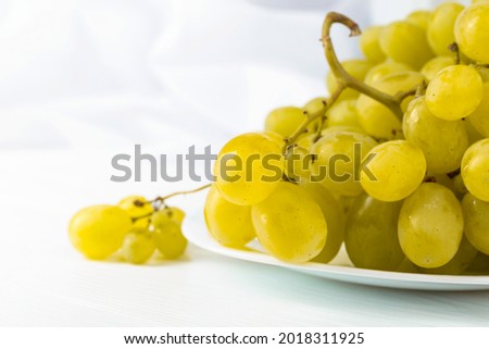 White grape cluster on a white table.