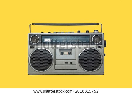 RADIO CASSETTE PLAYER ISOLATED ON YELLOW BACKGROUND. URBAN MUSIC FASHION FROM THE EIGHTIES. Royalty-Free Stock Photo #2018315762