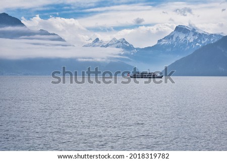 A lake, mountains, fog and a passanger ship crossing
