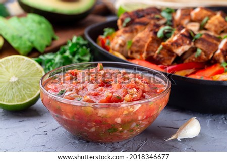 Tex-Mex cuisine salsa Asada sauce with roasted vegetables, served with Chicken Fajitas, horizontal Royalty-Free Stock Photo #2018346677