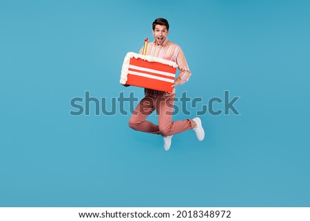 Full size photo of young man happy positive smile jump hold birthday cake slice tasty isolated over blue color background