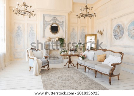 luxury rich sitting room interior in
beige pastel color with antique expensive furniture in baroque style. walls decorated with stucco and frescoes