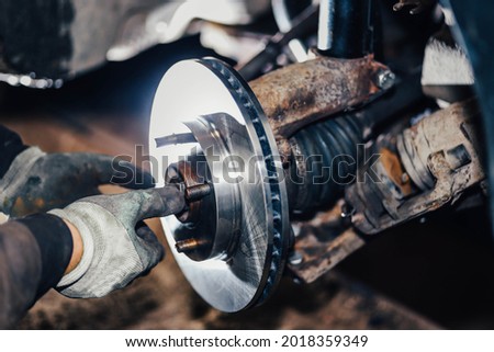 installation of a new brake disc in a car, repair of a brake system in a car service.