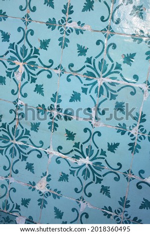 Traditional glazed blue and turquoise green or teal ceramic tiles or azulejos which cover many buildings in Lisbon, Portugal. These Portuguese tiles have many different geometric designs and colours. 