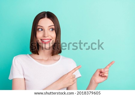 Portrait of attractive cheerful girl demonstrating copy empty space ad advert isolated over bright teal turquoise color background