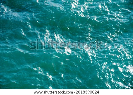 Sea water texture. Sunlight ray in surface of water. Abstract art background. Scenic natural design in water waves. Wallpaper for desktop.