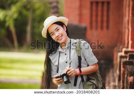 Photographer holding camera on tourist attraction in warm sunset
