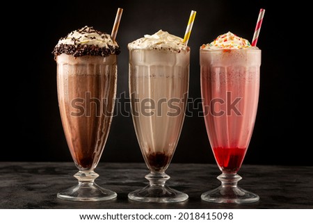 Three glasses of milkshake with assorted flavors. Chocolate, vanilla and strawberry milkshake. Royalty-Free Stock Photo #2018415098