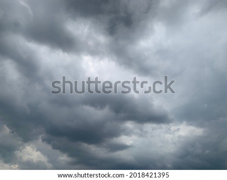 The stratocumulus clouds curled in a gray style are rounded together in sheets and layers and a heavy rain at Thailand. no focus
