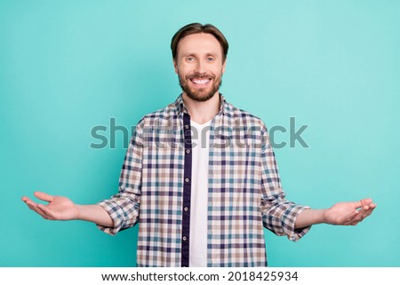 Photo of young cheerful man happy positive smile hold hands promo product advertise isolated over teal color background