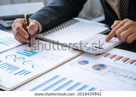 Businessman discussing analysis charts or graphs on desk table and using a laptop computer. Close up male analysis and strategy concept.