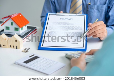 Male arm in shirt offers contract form on clipboard pad and silver pen to sign closeup.  sale home insurance agent concept