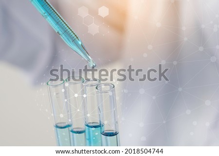 Biochemistry laboratory research, Scientist or medical in lab coat holding test tube with using reagent with drop of color liquid over glass equipment working at the laboratory.