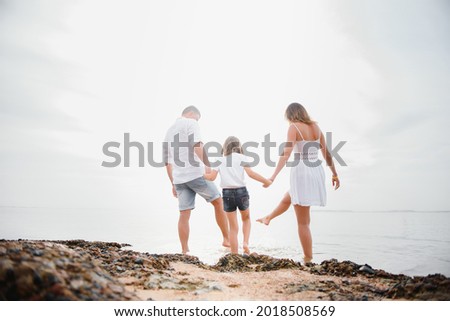 Happy family walking on the beach