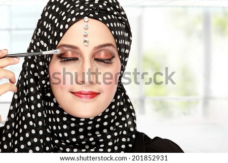 close up portrait of beautiful woman applying mascara on her eyelashes
