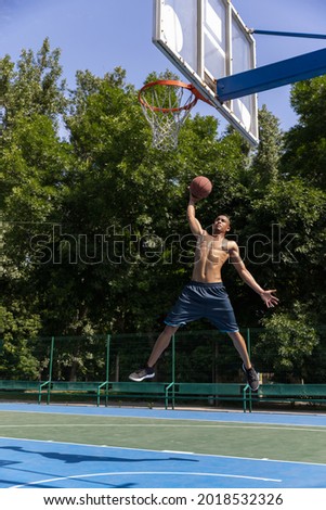 Scoop shot. Strong athlete african-american male basketball player training at street public stadium, sport court or palyground outdoors. Concept of healthy active lifestyle, motion, hobby.