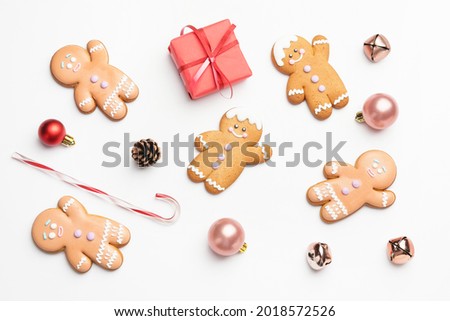 Tasty gingerbread cookies and Christmas decor on white background