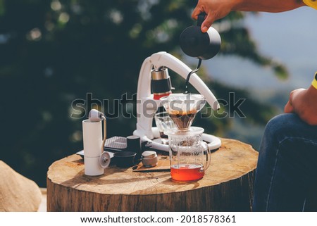 Pouring hot water into glass cup with drip,coffee time.