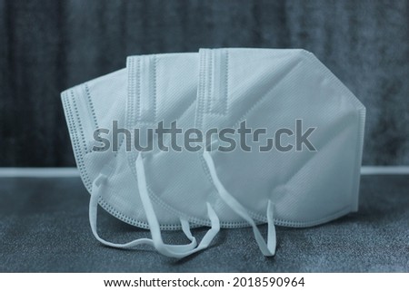 KN95 FPP2 disposable medical respirator white mask medical equipment on dark background. Royalty-Free Stock Photo #2018590964