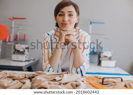 Woman tailor working with fabric and scissors
