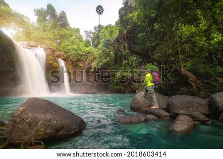 Tourists carry backpack, hiking nature trail, traveling ecotourism. Tourist trekking to see amazing beauty of Haew Suwat Waterfall. Unseen Khao Yai National Park, Thailand, UNESCO World Heritage Area.