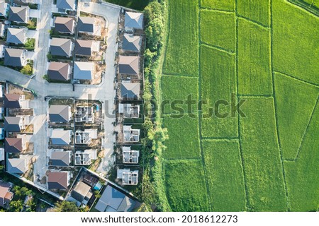 Land or landscape of green field in aerial view. Include agriculture farm, house building, village. That real estate or property. Plot of land for housing subdivision, development, sale or investment. Royalty-Free Stock Photo #2018612273