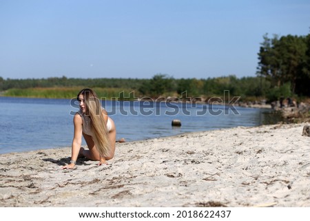 Woman in white bikini sitting on a sand