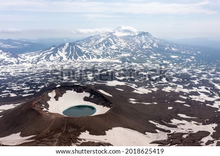 Gorely Volcano crater lake with Mutnovsky Volcano on the background. Kamchatka, Russia