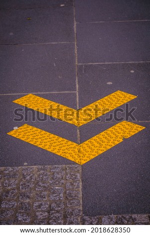 SANTIAGO DE COMPOSTELA, SPAIN - MARCH 19, 2021: Yellow signs indicating direction of travel on a street during the COVID-19 pandemic.