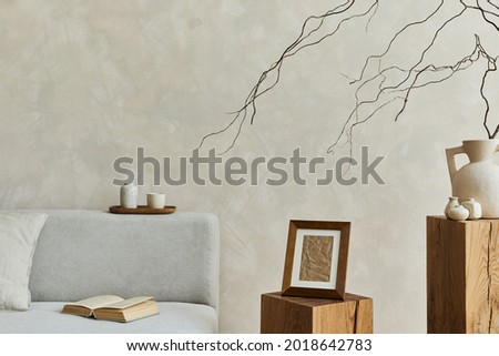 Stylish modern composition of living room interior with mock up poster frame, grey elegant sofa, wooden cubes, vases and personal accessories. Neutral colors. Template. 