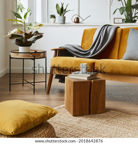 Interior design of scandinavian open space with yellow velvet sofa, plants, furniture, book, wooden cube and personal accessories in stylish home staging. Template. Royalty-Free Stock Photo #2018642876