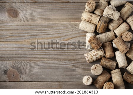 Heap of assorted wine corks on wooden background.