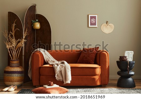 Modern concept of domestic interior with design sofa, wooden room screen, pillow, blanket, picture frame , side wooden stool and elegant personal accessories in stylish home decor. Template.