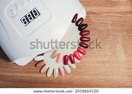 Samples of nail polishes of different colors are laid out on the manicure table for showing to clients.